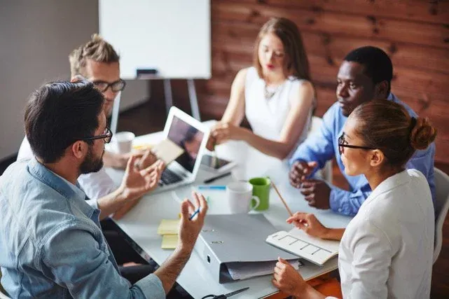 A leadership team in discussion around a meeting table