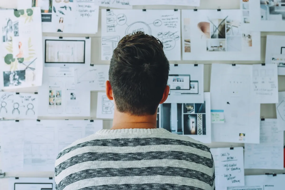A leader studying a wall of plans and diagrams